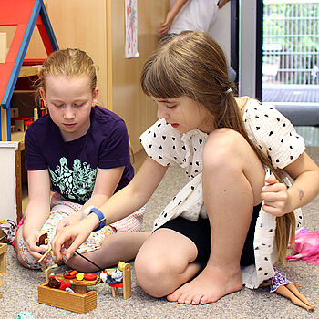 Schulkindbetreuung der AWO Ludwigsburg: Zwei Mädchen spielen in der Puppen-Ecke