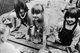 Drei Kinder spielen im Sandkasten