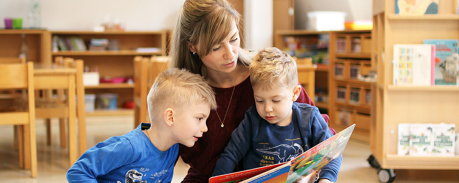 Eine Mutter liest ihren Kindern aus einem Buch vor