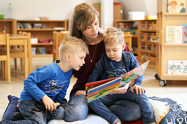 Eine Mutter liest ihren Kindern aus einem Buch vor