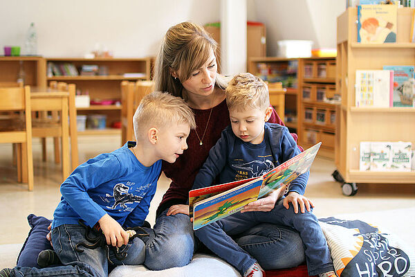 Eine Mutter liest ihren Kindern aus einem Buch vor